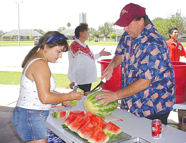 Los Fresnos Commissioner Alan Atherton slices some ice-cold watermelon that was given out free at  a previous celebration. Photo: LFN file photo