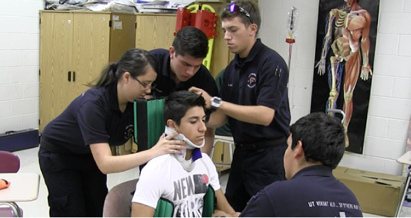 Students Practice Putting On a Back Brace on Victim of Auto Crash
