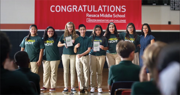 In this still from the commercial, students from Resaca Middle School can be seen receiving their award.