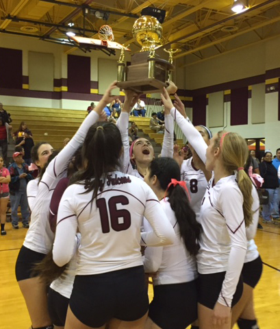 Jackie Kingsbury (pink headband) hoists the District Championship trophy, surrounded by her teammates, after the Lady Falcons victory over Brownsville Hanna.