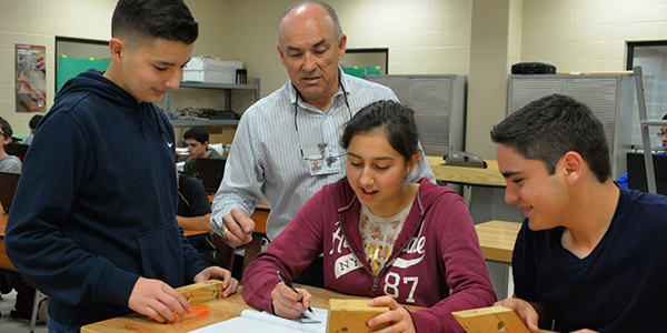 LFU Engineering Teacher Gil Gomez (standing) works with students on wood project. Photo: LFCISD