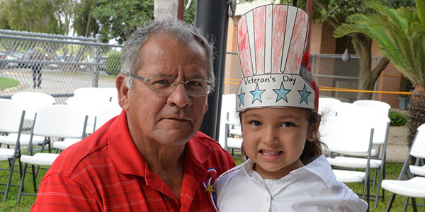 Veteran Juan Aguilar, granddaughter Gianna at Los Fresnos Elementary ceremony.